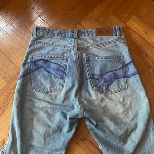 Baggy jeans med målning på baksidan - Unika ”boyfriend” baggy jeans med handmålad bild av händerna från ’Adams skapelse’ av Michelangelo på baksidan. Textilfärg som inte försvinner i tvätten. Skitsnygga slitna hål över knän och lår. Tyvärr för stora för mig så har inga bra bilder med dom på. 