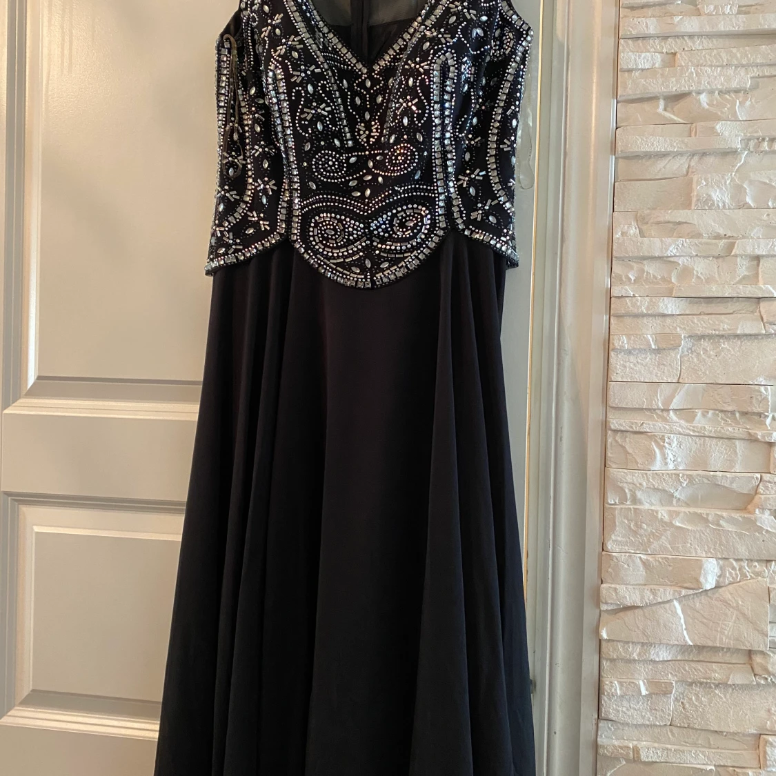 En lång svart klänning med pärl detaljer