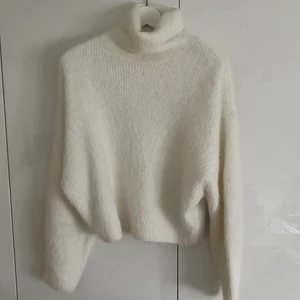 Vit stickad tröja - Säljer den här vita stickade tröjan från H&M, har endast använt ett fåtal gånger så den är i bra skick. Tröjan har polokrage, och lite kortare i modellen. Strl XS. 
