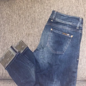MET jeans med gulddetaljer - Säljer dessa ursnygga MET-jeans. Köpta för 2500 kr på fiorucci i Göteborg. Säljes för billigt pris på grund av att dragkedjan är trasig, behöver fixas en ny. Storlek 32 (passar någon med S/M, lågmidjade).