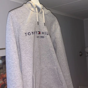 Tommy Hilfiger Hoodie - Säljer denna hoodie då den är för liten för mig. Äkta och knappt använd. Köpte den förra sommaren men sedan dess har den bara hängt i min garderob pga för liten storlek. Inga fläckar eller skador alls så den är som i nyskick, den tvättas innan frakt.     Pris kan diskuteras vid snabb affär, kom privat för fler frågor.      Köpare står för frakt!!!