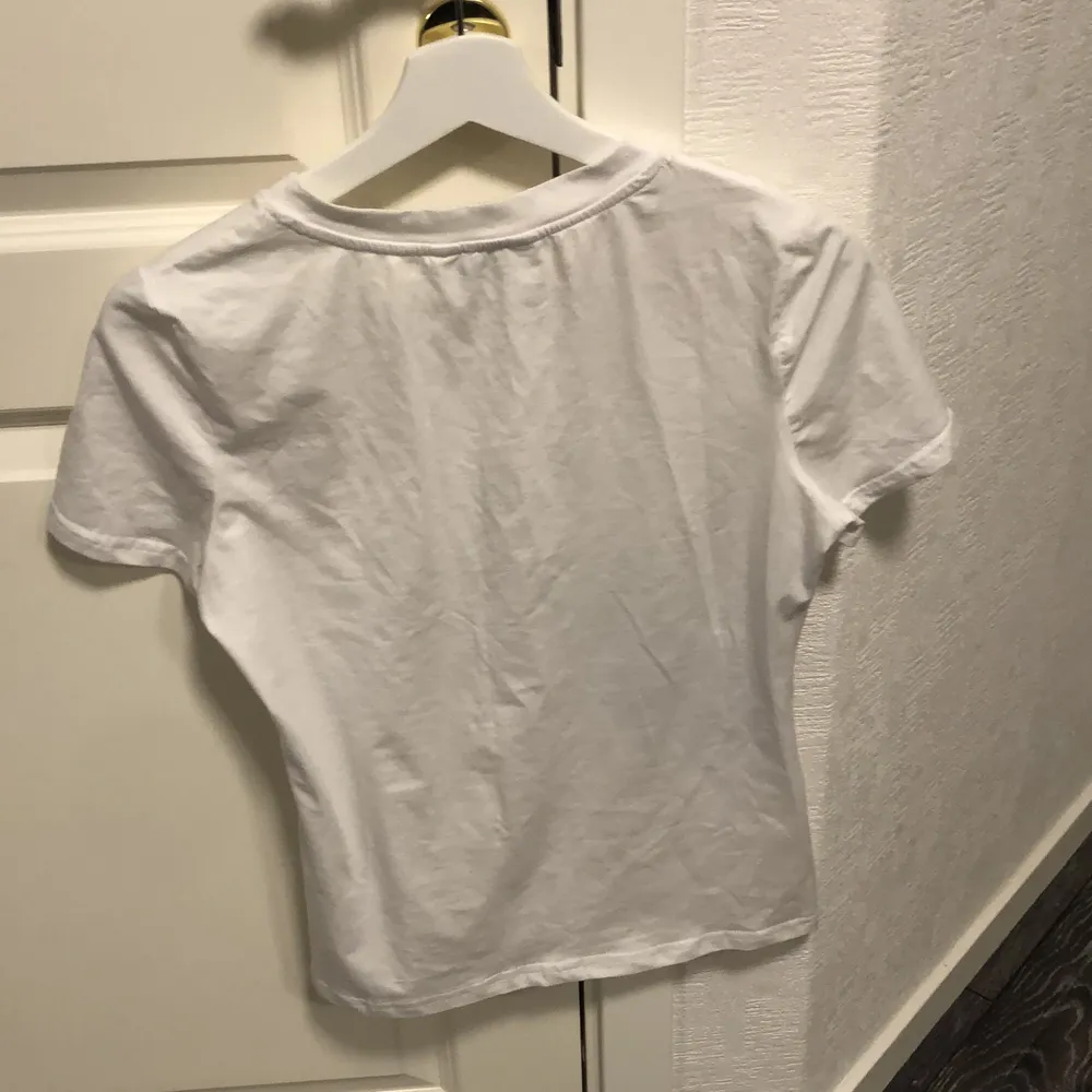 En vit t-shirt med en katt på framsidan. Aldrig använd. Frakt tillkommer . T-shirts.