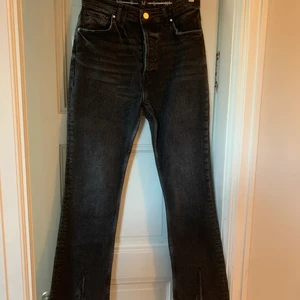 Svarta jeans med slits - Ett par sjukt snygga svarta jeans med slits framtill. Strl M från bok bok, mkt sparsamt använda.