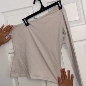  oneshoulder topp - Krämvit onesholuder topp från NAKD. Strl L men passar även M