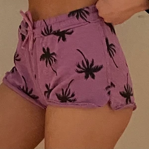 Shorts - Ett par fina lila shorts med palmträdsmönster köpta på Lindex. Storlek 158/164 och passar XS/S, kanske M också. Man kan knyta i midjan och det är lite rivningsdetaljer längst ner. Skönt material. 100% bomull. Haft ett tag men aldrig använt. Kan mötas i Umeå eller skicka om köpare står för frakt. Spårbar: 66kr, icke-spårbar: 30kr