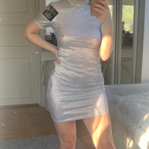 Silverklänning från Nelly - T-shirt-klänning från Nelly.com. Aldrig använd och lapp kvar.   