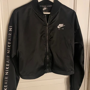 Nike air sport tröja - Svart Nike air tröja med dragkedja. Tunn och glansig i matrealet. Kortare modell men lång i armarna.