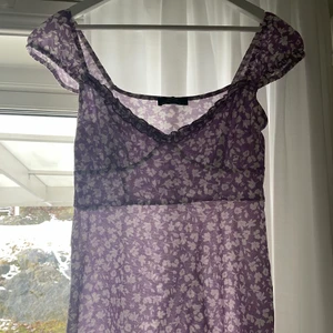 Blommig klänning  - Lila/vit blomning sommarklänning från bershka! Fint skick använd fåtal gånger. Storlek M