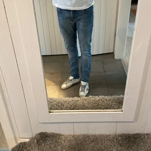 Nudie Jeans Lean Dean -  Hej! Jag säljer nu mina Nudie jeans i en ljusblå tvätt då de ej kommit till användning.  Jag köpte jeansen i höstas men har bara hamnat i garderoben. De är väldigt sparsamt använda & är därmed i nyskick. Modellen heter lean Dean och är i storlek 32/32. Nypris på byxorna var 1500:- men vill nu bli av med dem & säljer därför de till ett förmånligt pris.   Då byxorna är från nudie jeans får man gratis reparation vid eventuella skador eller slitage. Lämna in jeansen till dem så lagar de dem åt dig 