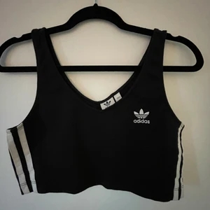Adidas topp - Såå snygg svart crop top från Adidas. Men som inte kommer till användning längre. Helt slutsåld 