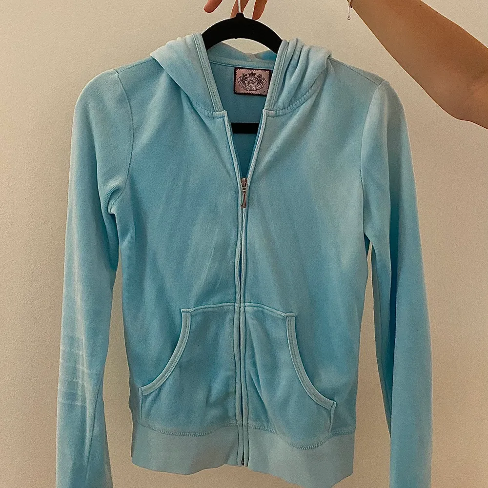 Ljusblå Juicy Couture hoodie med logga där bak i froté-material. Koftan är i bra skick och är knappt använd. Superfin ljusblå färg som passar perfekt till våren och sommaren!🤗💞. Hoodies.