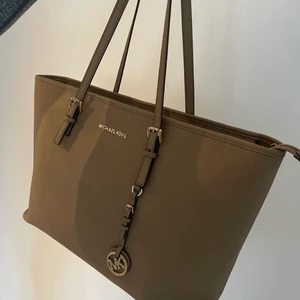 Michael Kors  - Hej! Michael kors jet set väska säljes. Jättefint skick, förutom att den är lite slitet vid hantaget, inget som stör användning eller syns. Därav priset. 