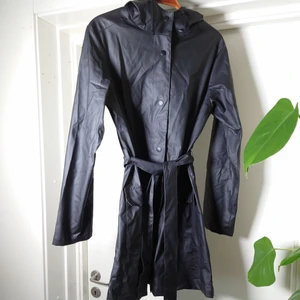 Regnrock - Svart regnrock med huva och band i midjan. Perfekt skick men lite skrynklig på bilderna💎