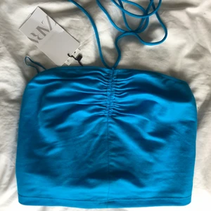 Blå topp - Säljer denna jättefina blåa topp eftersom den är för liten för mig. Taggen är kvar och är helt oanvänd, alltså i topp skick. Storlek S men skulle säga att den passar xs-s.