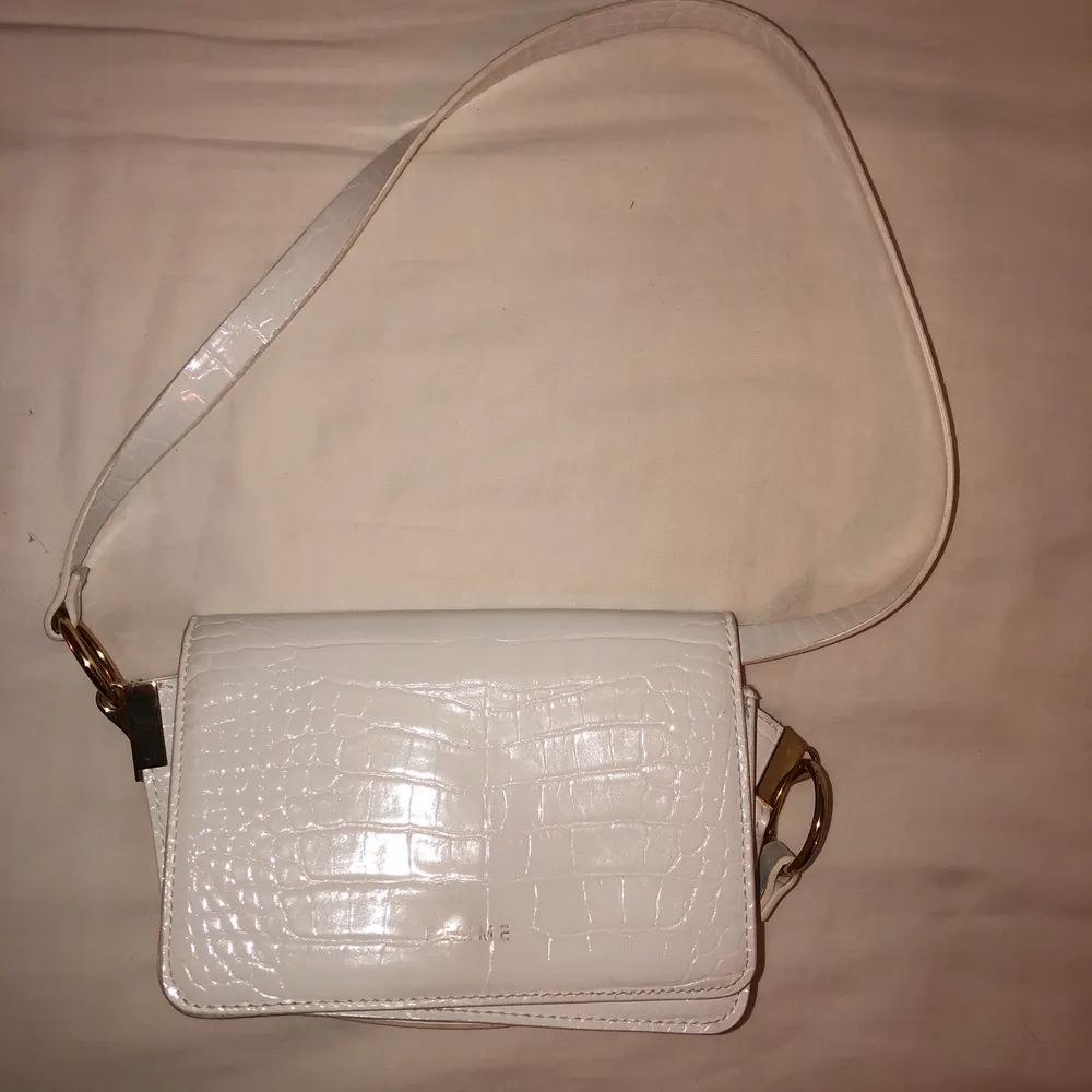 En söt vit handväska med band som går att ha både korta och långa . Väskor.