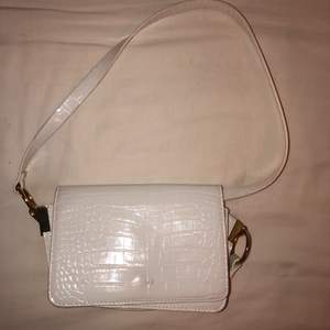 En söt vit handväska med band som går att ha både korta och långa 