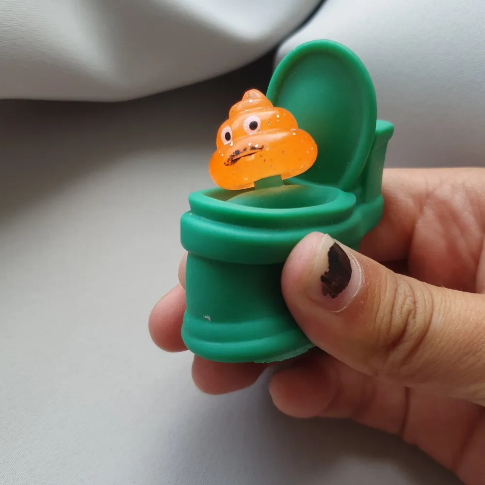 En rolig fidget toy grön snygg orange och lite glittrig man poppar upp självaste bajskorven🙈. Övrigt.