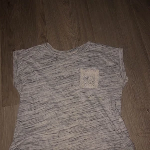 Strl 134-140 - Grå t-skirt med lite spets på ryggen, använd fåtal gånger. Dock ihop syd en gång längst ner, därav ser den lite sliten ut längst ner men inget som syns. ( är mening att den ska va öppen längst ner å inte ihop syd) 
