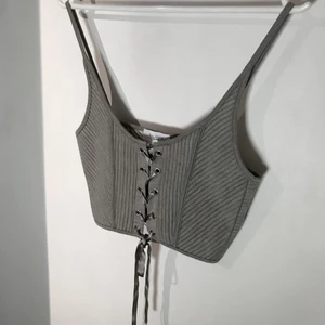 Snörad topp - Helt oanvänd snörad topp från BikBok i strl S. Kan knytas tightare eller lösare beroende på hur du vill ha den. Mjukt material som formar sig bra efter bysten. Säg ett pris som känns rimligt för dig vid intresse! Kontakta mig för fler bilder eller frågor!