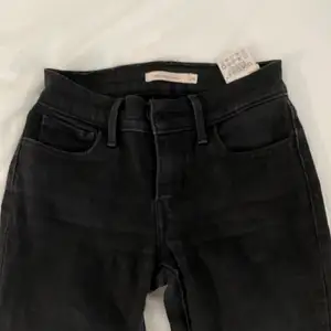 Svarta jeans från Levis i storlek 24W i modell 710. Inte så stretchiga 