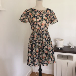 Supersöt sommarklänning - Jättefin blommig klänning med en inbyggd underkjol. Superfint mönster och en väldigt fin öppen rygg. I storlek 34, men passar mig som oftast har storlek 36. Bara använd ett fåtal gånger, och skicket är superbra förutom ett litet hål vid dragkedjan (syns på bild 3). Detta hålet syns knappt med jag kan sy igen det om du skulle vilja det :). Paketet kan postas, men då får du stå för frakten!