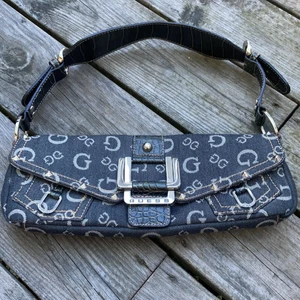 Guess väska - Så snygg baguette väska från Guess. Fint begagnat skick. Jeanstyg o mörk jeansblå färg. Längd 30 cm höjd 12. Frakt tillkommer 70kr 