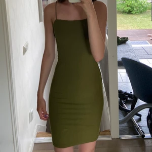 Figursydd klänning - Figursydd klänning i en millitärgrön färg som inte kommer till användning längre:) Den har två enkla fläckar där fram som går bort i tvätten, kan tvätta klänningen innan den postas om det önskas!