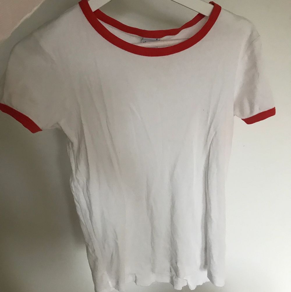 En nice vit tshirt med röda detaljer som har den perfekta längden, inte för lång och inte för kort. Storlek small.. T-shirts.
