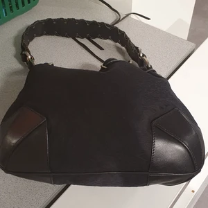 Åkta DKNY handväska  - Säljer min åkta DKNY handväska som är I bra skick men användade många gånger.Säljer den eftersom jag inte användar den längre. Och den är mycket storre än banquet väska och kan ta fler saker. Man kan hållar de I olika stilar. Finns fler bilder och bud I kommenterna eller köp direkt for 500