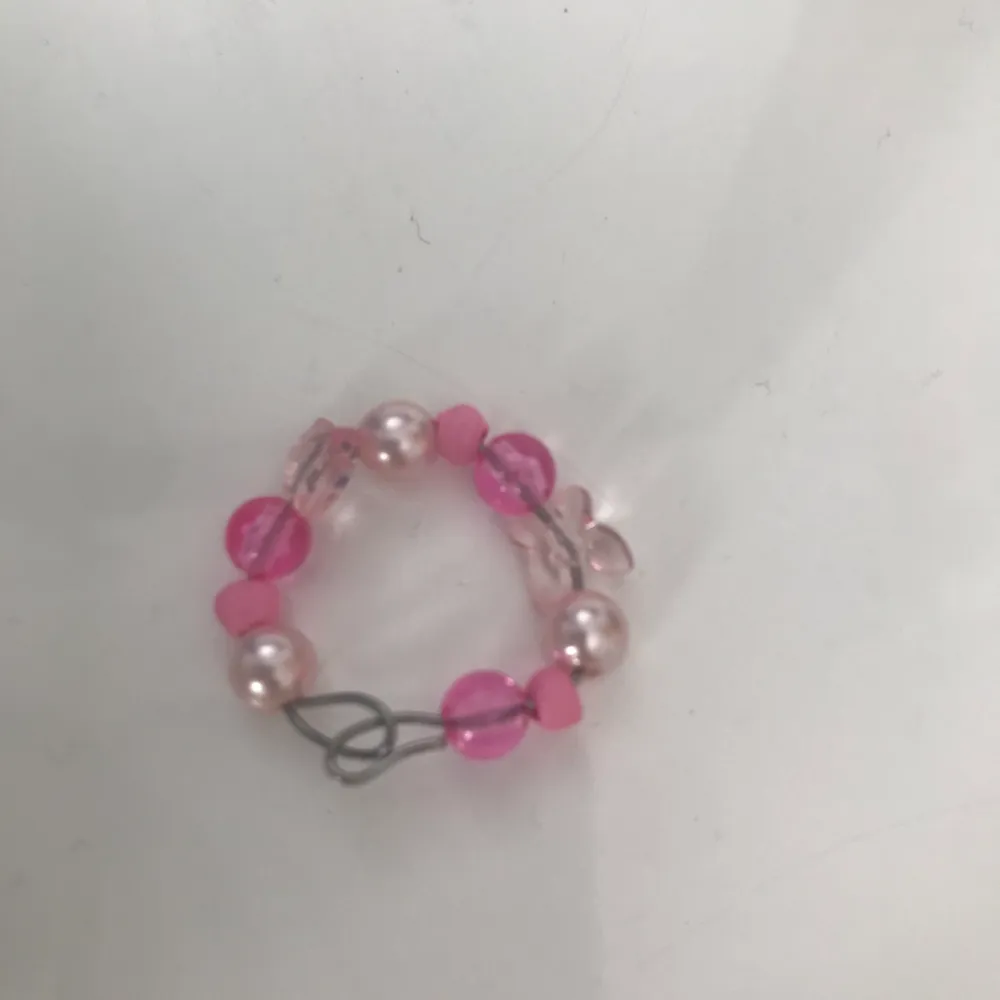Ringen är gjord av ståltråd och har rosa pärlor.🌸           Ringen är stängd och då inte justerbar men passa nästan alla fingrar!. Övrigt.