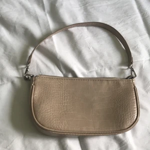 Handväska  - Beige handväska i krokodilmönster, knappt använd. Avtagbart axelband. Fraktas eller hämtas upp!