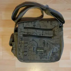 En fåtal använd väska från märket ”Mailbul”. Den är rymlig och har en axelrem samt består av en militär gröngrå färg.