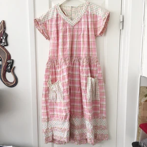 Mönstrad rosa klänning stolek M-L - En mönstrad klänning storlek M-L, endast använd några gånger. Lite vintage bondgårds stil. Handgjord och köpt på en marknad i Italien. Skönt material. Passar någon med mindre byst eftersom den kan sitta lite tajt om man har större än en C kupa. Finns en dragkedja där bak. Frakt ingår ej