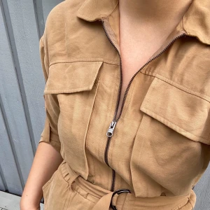 Kort klänning med snygga detaljer⚡️ - Älskar den här lite tuffare klänningen, jag är 170cm lång och den är tyvärr lite för kort för mig. Snygg dragkedja som man kan anpassa hur mycket/lite klyfta man vill visa och ett skärp som kan spännas åt i midjan. Ärmarna är halvlång/korta och ena knappen är tyvärr sönder och kan inte knäppas upp, men inget som påverkar klänningen om man vill ha knapparna knäppta! 💕