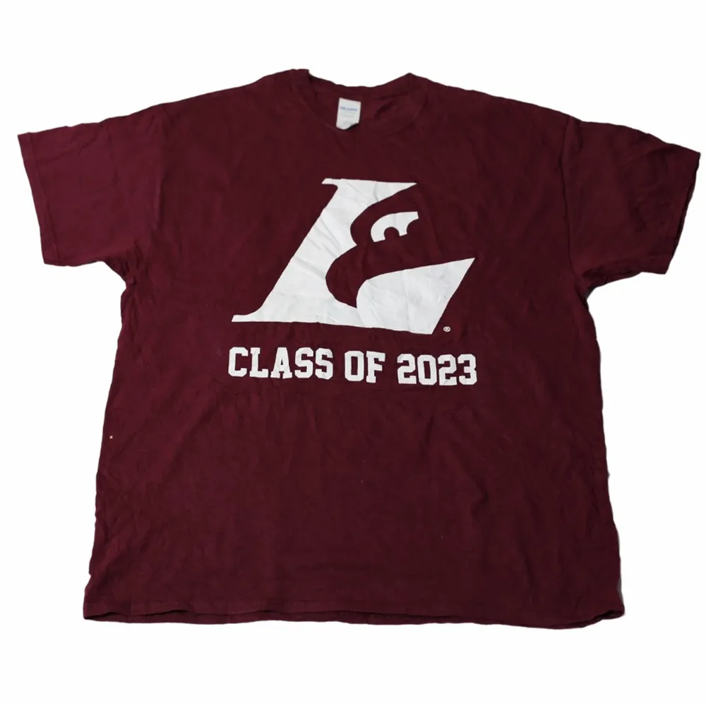 En tröja med ett fint vinrött tryck. Tillhör ett universitet och deras klass av 2023. Perfekt för dig som vill ha backgrund i dina plagg men även om du är ute efter denna efterfrågade färg! Köpt på Ross.. T-shirts.