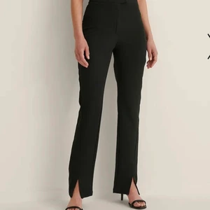 Kostymbyxor med slits - Riktigt snygga kostymbyxor från na-kd med slits där fram, sitter verkligen jätte bra (säljer pga att de blivit för små) har dock nästan aldrig använt de för det inte har varit rätt tillfälle! Köpte för 400kr💖 *köparen står för frakten!