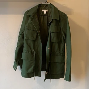 Cargojacka st34 - Jättefin grön färg, från H&M Trend, knappt använd, gjord i bomull, perfekt till hösten, kan dras in i midjan för en annan siluetter, säljer pga för liten