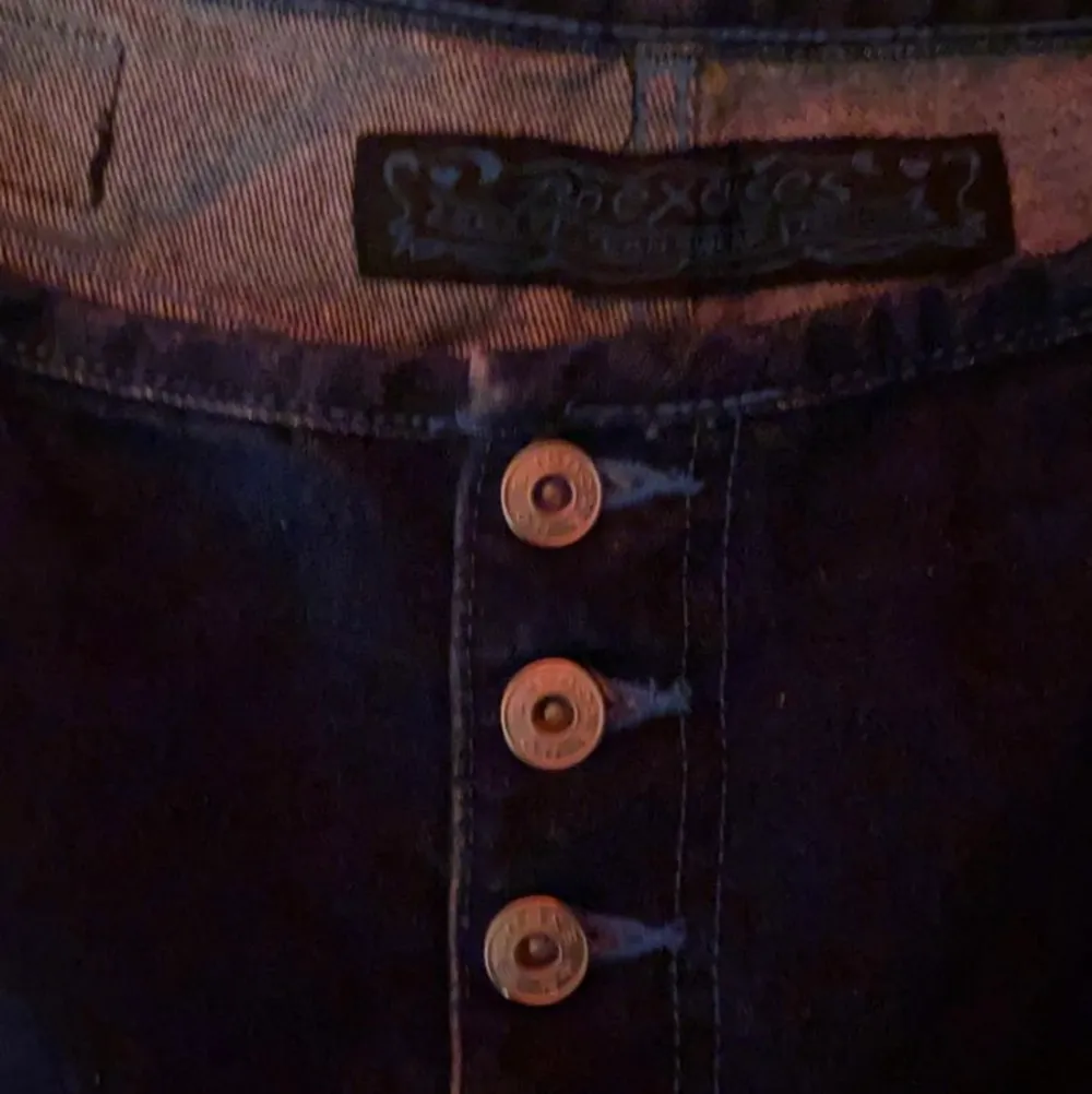 köpa secondhand, mörkblå jeans med ljusblå sömmar, igen dragkedja byxorna har knappar hela vägen upp, dem är inte lågmidjade men dem går ungefär under naveln.. Jeans & Byxor.