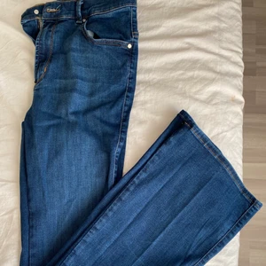 Mörkblåa byxor  - Tighta övertill men vida längre ner. Stl M 150 kr 