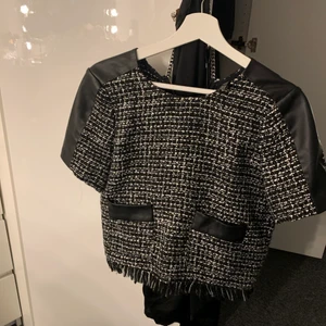 Topp - Såå fin tshirt med skinndetsljer på, endast använd en gång och är i sånt fint skick. Har en dragkedja ibak vid nacken