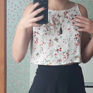 Blommigt croppat linne - En kort vit topp med blommor på. Fladdrigt och bekvämt. Sytt själv.