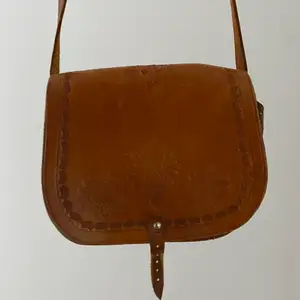 Vintage väska i brunt läder! Någon deffekt (sista sidan) vilket jag endast tycker adderar charm till väskan😊 väskan har broderier som bildar så fina mönster på fram och baksida!köpt för 500kr