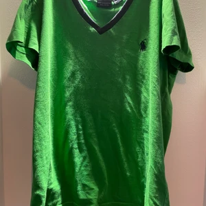 Grön v ringad ralph lauren sport t shirt - Jätte fin grön ralph lauren sport t shirt som är v ringad t shirt med mörkblåa ditaljer. Köpt second hand för ca 6 månader sen. Köparen står för frakt💕
