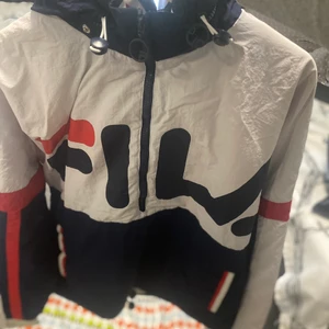 Fila jacka - Storlek S. Ny pris 1500 säljs för 650. Det är inget stora fel på jackan vilket ni kan se på bilderna och har inte används så mycket. Jackan är vattentät och är dessutom en vindjacka. Den är väldigt bekväm och skön. Luvan kan man både dra in och ha ute. Luvan har en dragkedja så du kan ta in luvan med hjälp av dragkedjan eller ha den ute på dagar som det t,ex regnar. Jackan ör väldogt smidig och håller dig varm och skön. Det kostar 50 kronor för frakt annads finns de i uppsala att hämta