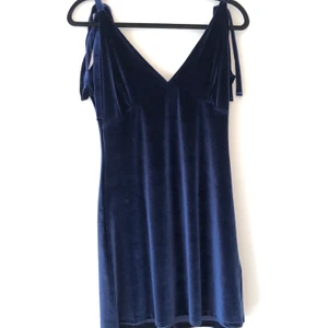 Blå sammetsklänning med knytning - Superfin blå sammetsklänning från Na-Kd med knytning i axelbanden så man kan anpassa längden av banden och en snygg detalj. Endast provad. Storlek S men passar en XS också.