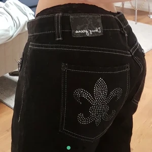 Jeans - Ett par svarta lågmidjade jeans med mönster på fickorna. Säljer pågrund av att det inte var min storlek