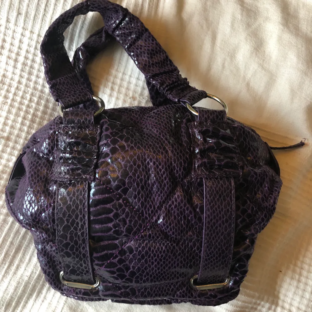 Jättecool lila färg med krokodil-mönster. Mindre väska men man får plats med mycket och kan bäras på axeln. Köpt secondhand, knappt använt så i bra skick!💕💞 Priset är exl frakt. Väskor.