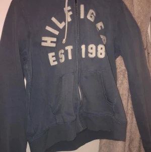 hilfiger zip up hoodie - Ljus blå zip up hoodie som är i bra skick. Frakt ingår såklart