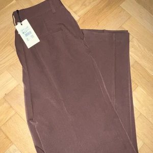 Kostymbyxor - Helt oanvända raka kostymbyxor från bikbok i en fin brun färg, storlek 34 passar 36 också beroende hur du önskar pass formen. 