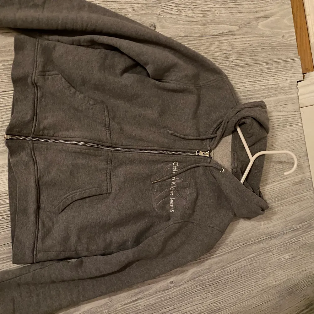 Grå Hoodie med en dragkedja från Calvin Klein.. Hoodies.